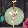 Détail du porte-clés pompon vert clair avec strass et breloque coeur I Love You - Cœur en bois + Pompon vert clair