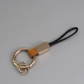Porte-clés en cuir marron avec anneau métallique doré et cordon tressé noir élégant - Orange + Or
