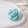 Macro view of blue rose shaped scented candle on satin background for wedding gift - Gradient Teal