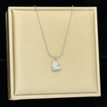Detail of silver heart pendant necklace displayed on a textured gold jewelry stand - Heart Silver Color