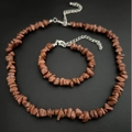Detailed shot of brown goldstone necklace and bracelet set on black leather background - Bracelet / Gold Sandstone