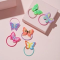 Set of six colorful butterfly hair ties for kids with soft PVC charms on pink background - Butterfly Hair Tie
