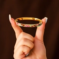 Enameled gold titanium steel bangle with colorful floral patterns on a model's hand - 6mm Enamel / Patchwork Flower (A708)
