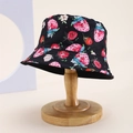 Detail of a black kids bucket hat with vibrant strawberry prints on a wooden stand - Kids One Size / Black (Strawberry/Flower)