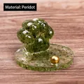 Cat paw resin ornament featuring peridot natural crystal gravel on wood table - Peridot