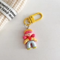 Detail van schattige cartoon meisje sleutelhanger met roze haar op beige achtergrond - Geel