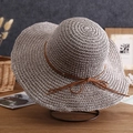 Close-up of light gray straw hat texture with brown ribbon on minimalist metal stand - One Size / Solid Color with Cord - Grey