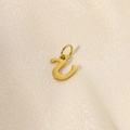 Detail of gold-plated stainless steel initial pendant on elegant beige silk fabric - Letter-U