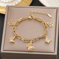 Double-layered 18k gold butterfly bracelet on a jewelry display with warm lighting - Gold Double Layer Butterfly Style (5122)