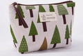 Close-up of small canvas makeup bag with green tree pattern and leather zipper puller - Jenny J. Tree