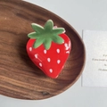 Close-up of strawberry acrylic hair claw clip with white dots on a wooden tray - Red Strawberry