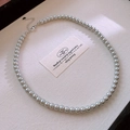 Close-up of silver-grey pearl necklace with silver clasp on beige jewelry box - 6mm Round Bead Style / Gray