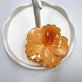 Glossy orange flower hair claw clip on a white wave tray for beach vacation styling - Orange (Rolled Flower)