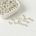 Polished silver metal spacer beads for jewelry making in a white ceramic bowl - Silver Plated