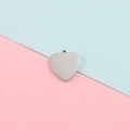 Colgante de corazón de acero inoxidable pulido accesorio DIY sobre fondo rosa y azul claro - Color Acero