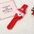 Detail eines Weihnachts-Klapparmbands mit Plüschbär auf rotem Vlies-Stoffarmband - Bär-Stil