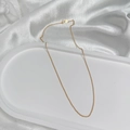 Detail of a thin gold-plated S925 silver O-chain necklace on a white ceramic display tray - Round O-Link Chain / 45cm / Gold