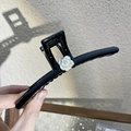 Detailansicht der schwarzen Haarspange mit weißer Kamelie, Perle und Goldrand - Weiße Kamelien Haarkralle