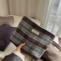 Detailopname van de vintage geruite tweed toilettas met een eenvoudig stoffen label - Blauw en Koffie Grote Ruit