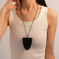 Primo piano di una collana pendente clochette in ecopelle nera su una modella - 5# Collana Maglione Piccola Borsa in Pelle Triangolo Nero