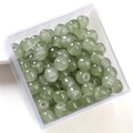Green cylindrical glass jade beads in a transparent box for DIY jewelry making - Dark Grey Apple Bead