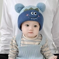 Niedliche dunkelblaue Strickmütze für Babys mit Bommeln und Monstergesicht für den Winter - Doppel Pompon Haustier - Blau