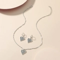 Détails macro de l'ensemble collier et boucles d'oreilles cœur vintage au motif filigrane - Parure collier et boucles d'oreilles