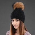 Close-up of the black cable knit texture and premium raccoon fur pom-pom on the winter hat - Black + Natural Pom Pom