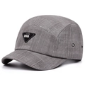 Detail of grey 5-panel cap featuring textured grid fabric and a black triangular metal logo - Adjustable / Dark Gray