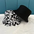 Close-up of double-sided bucket hats in solid black and cute panda print patterns - M / Black & White
