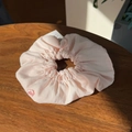 Detailed view of a pink pleated puff scrunchie with floral button on wood background - Light Pink Button Puff Scrunchie Large