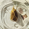 18K woven gold mesh pendant with raw Tiger Eye crystal stone on white textured cloth - Gold Wire Tiger Eye