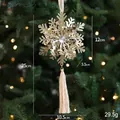 Goldenes Schneeflocken-Ornament mit Kristall und Quaste an einem Weihnachtsbaum - Goldene Schneeflocke / Gold