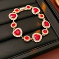 Detalle de pulsera dorada vintage con gemas rojas y cristales brillantes - Pulsera de Diamantes de Imitación Corazón - Dorado - Rojo
