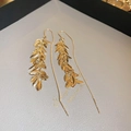 Makro-Detail von vergoldeten Blatt-Quasten-Ohrfäden auf einem Schmuckkissen - Ohrhaken Ohrfädler - Echt Vergoldet / Gold