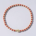 Elegant elastic beaded bracelet featuring a mix of polished gold beads and red seed beads - Red and Gold