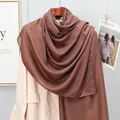 Detail of coffee brown linen-feel scarf showing smooth texture on beige trench coat - Coffee