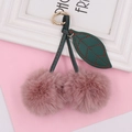 Detail of pink plush cherry keychain with green faux leather leaves and golden clasp - Spring Ring / Dusky Pink