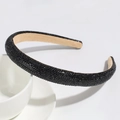 Close-up of luxury black rhinestone headband with beige velvet lining on ceramic plate - Black