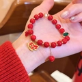 Nahaufnahme eines roten Achat-Perlenarmbands mit dekorativem goldenem Schaukelpferd-Charm - Jährlicher Frieden Stil 3 (8#)