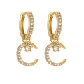Macro shot of gold crescent moon earrings encrusted with sparkling cubic zirconia stones - Gold Color White Zircon Moon