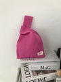 Close-up of fuchsia knitted tote bag with hollow weave texture and Hilldi brand label - Cranberry
