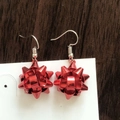 Detail of red Christmas gift bow earrings on white card display over dark wood surface - Red Christmas Flower Ball