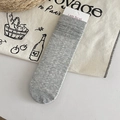 Calcetines grises de punto trenzado fino sobre una bolsa de lona con estilo relajado - Gris claro
