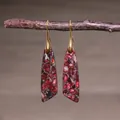 Close-up of teardrop imperial stone earrings hanging on a rustic branch background - Red Purple Stone Patchwork Trapezoid Style (ER1034-1)