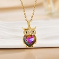 Macro detail of golden owl pendant featuring a rainbow crystal heart and crystal eyes - Gold Owl/Heart Rainbow Gem