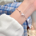 Silver link bracelet featuring a white heart gemstone and metal cross star charms on wrist - S369 Silver