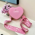 Detailed macro view of pink heart-shaped bag with wide patterned woven shoulder strap - Pink