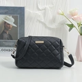 Black quilted crossbody bag with gold decorative bar and stylish woven shoulder strap - Black