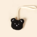 Close-up of cute plush black bear pacifier clip with cream ribbon on yellow background - Black